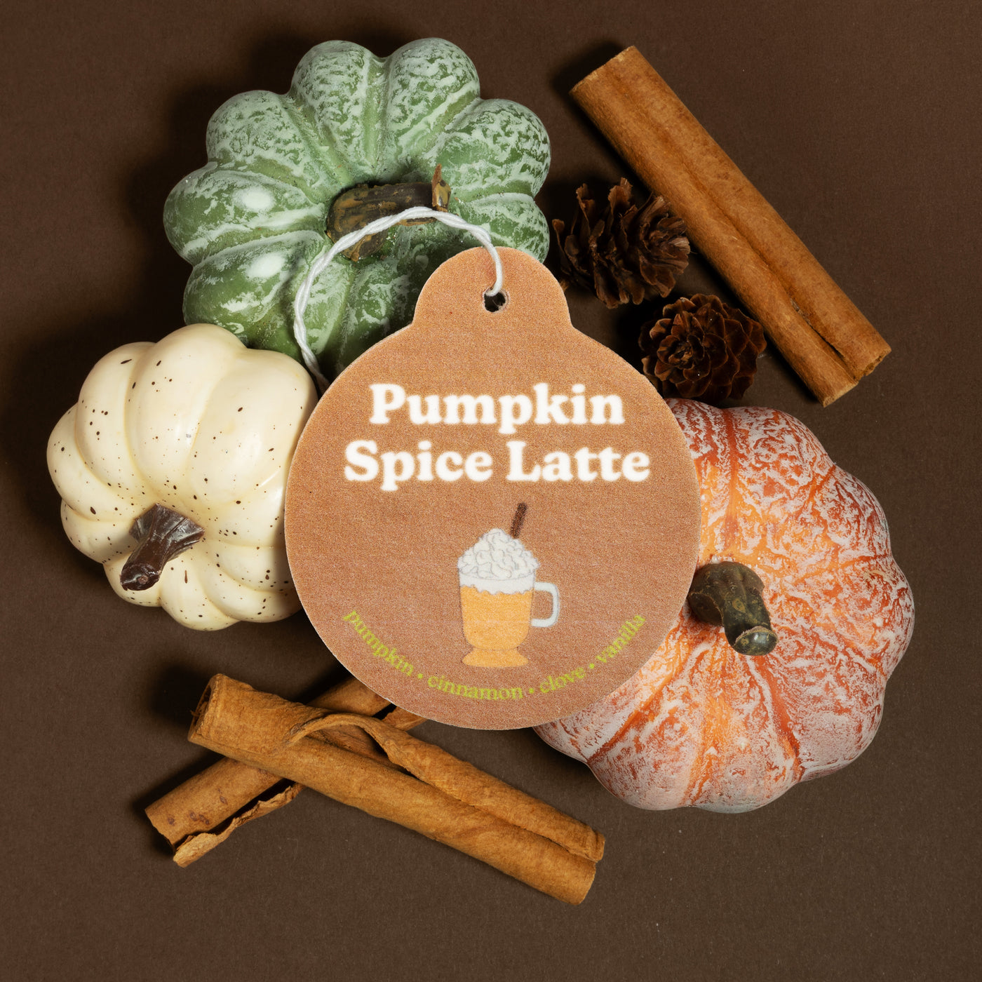 Happy Wax Pumpkin Spice Latte Car Charm with pumpkins and cinnamon sticks on brown background