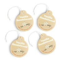 Four round tan car charms with white string, labeled "Vanilla Sandalwood" with vanilla flower and bean illustrations.
