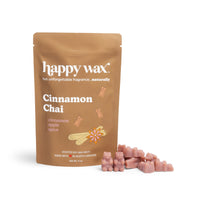 Tan pouch of Cinnamon Chai wax melts with pink wax cubes displayed beside it.