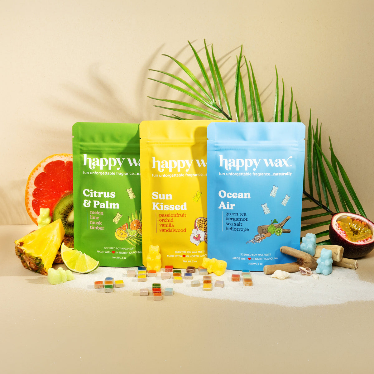 Three 'happy wax' wax melt packages on a beige-colored background with tropical decorative items.