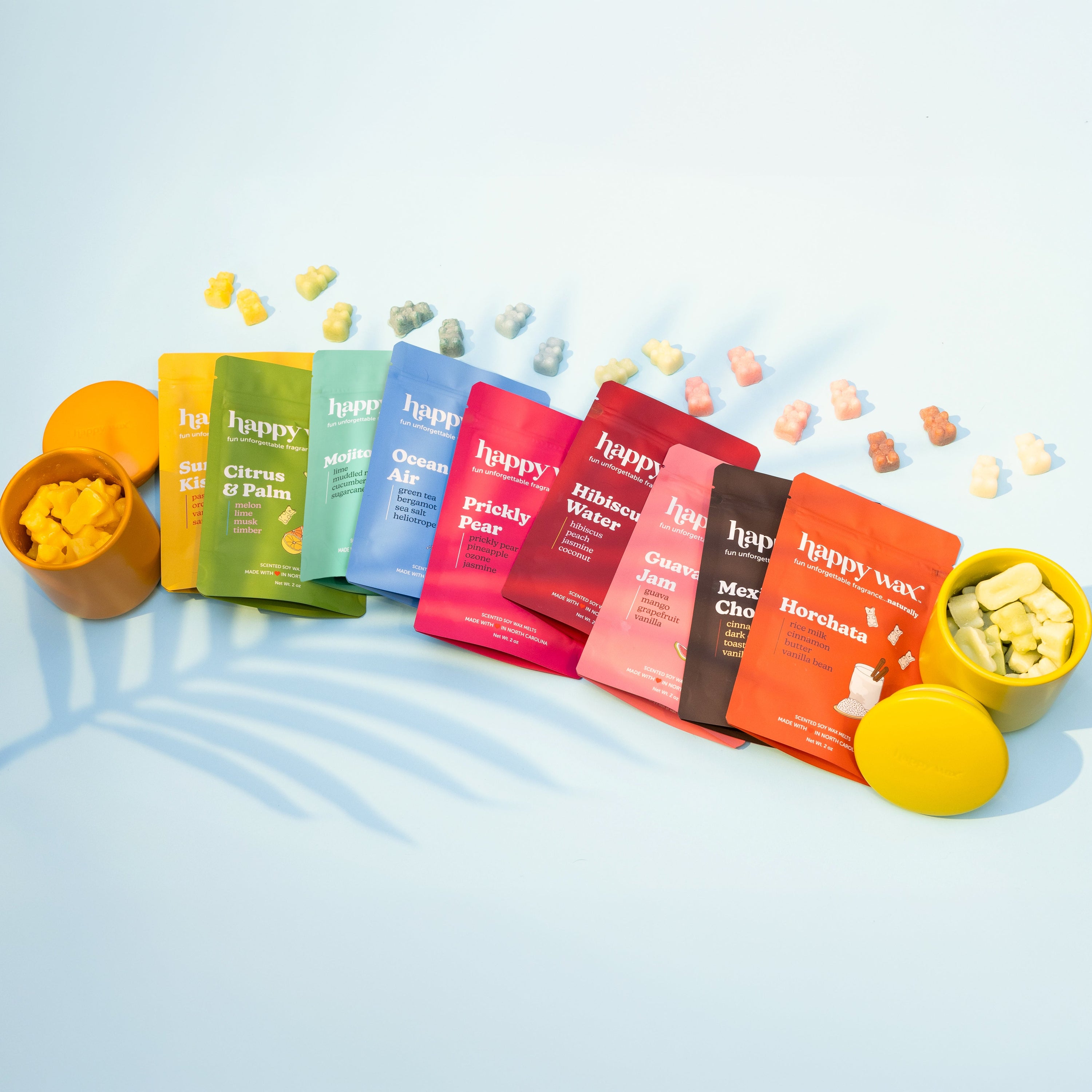 Colorful pouches of Happy Wax melts on a light blue background