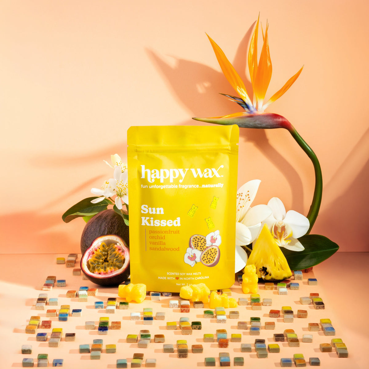 Happy Wax Sun Kissed wax melts packaging with flowers and fruit on a mosaic background
