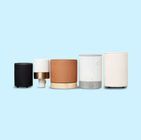 variety of wax warmer styles and colors on blue background