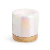 White ceramic wax warmer with wooden base and open top bowl.