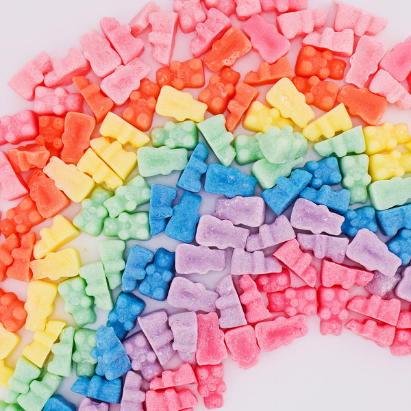 Assorted sugar-coated gummy candies in pink, red, orange, yellow, green, blue, and purple arranged in a circular rainbow patt