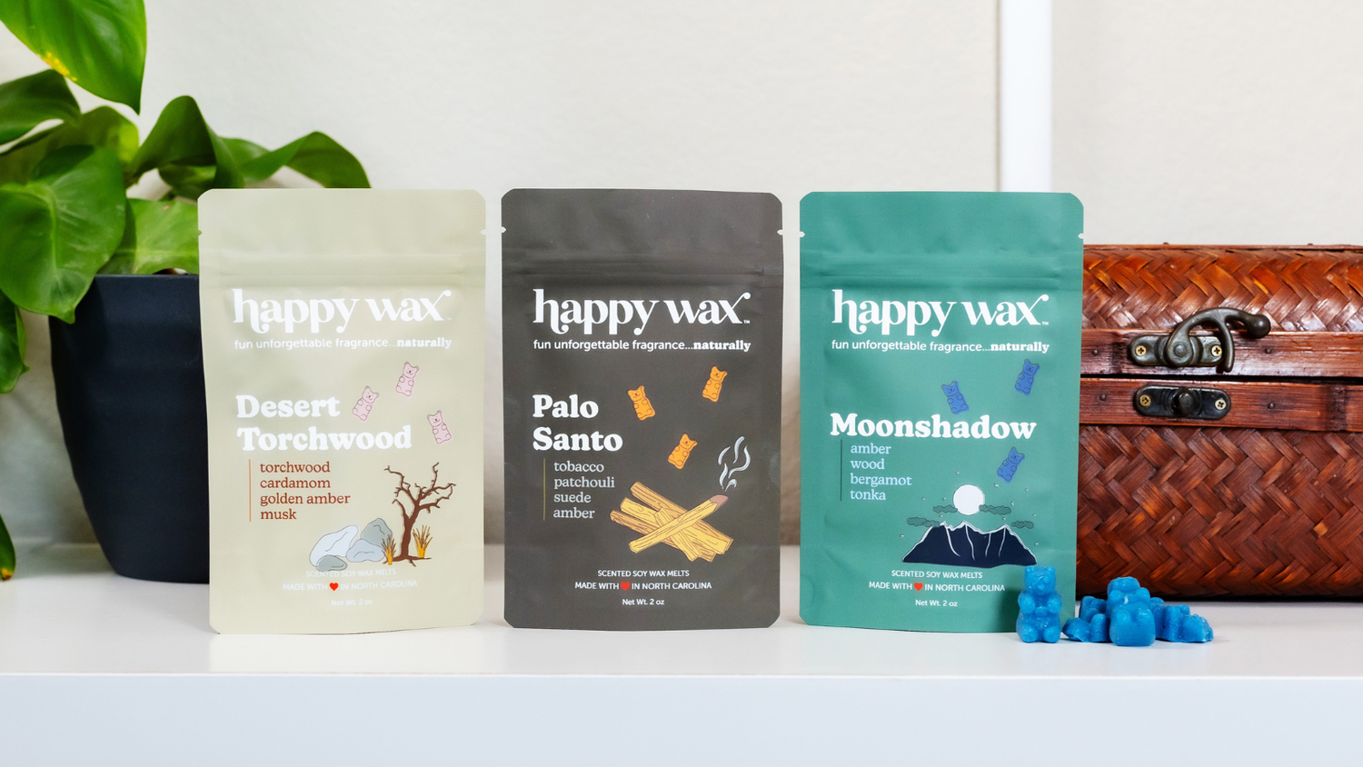 Happy Wax Wanderlust collection on white countertop with greenery and basket in background