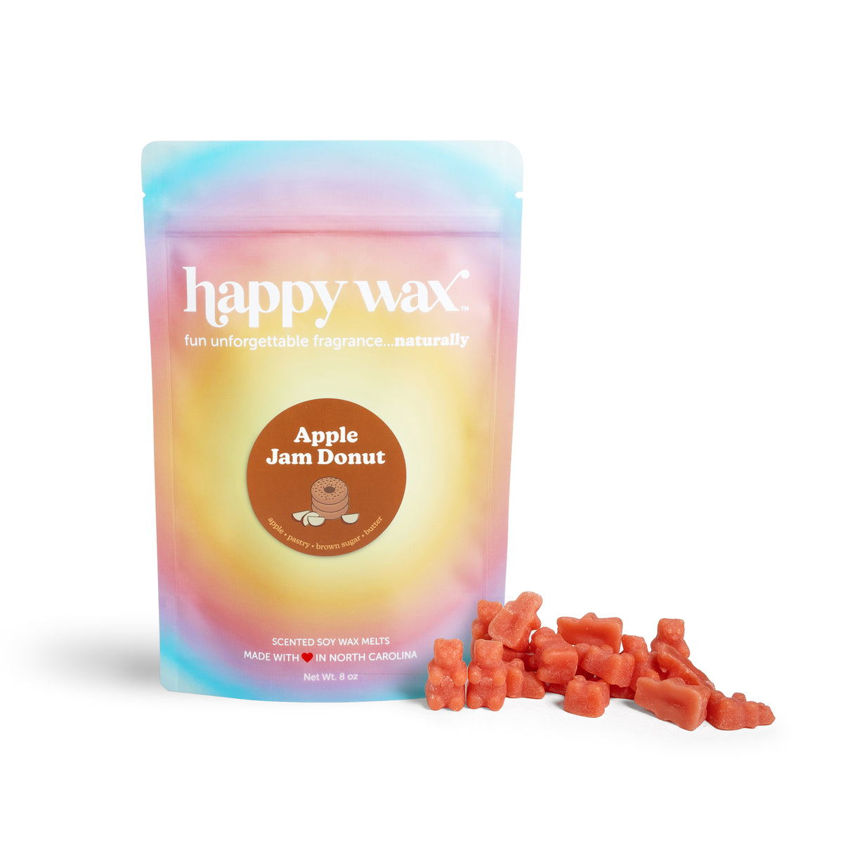 Pastel gradient pouch of happy wax brand soy wax melts with Apple Jam Donut label, accompanied by red wax melt chunks.