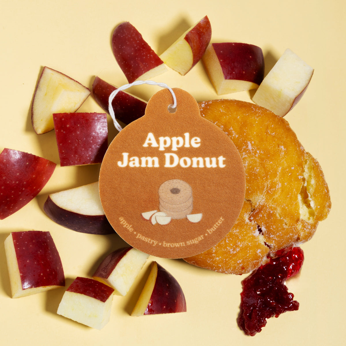 Happy Wax Apple Jam Donut Car Charm with apples and Apple Jam donut on pale yellow background