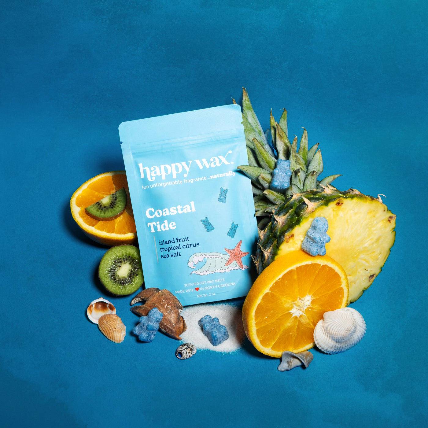 happy wax Coastal Tide pouch with tropical fruits and shells on a blue background