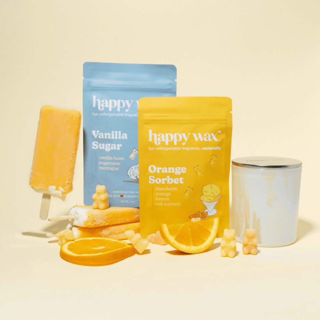 Happy Wax melt pouches and storage jar on cream background with oranges and melting popsicle