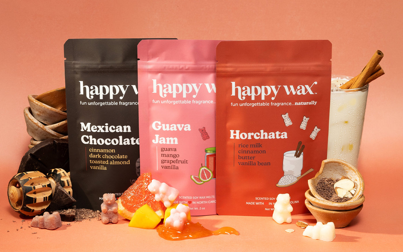 wax melt pouches on coral background with grapefruit, chocolate, and horchata drink