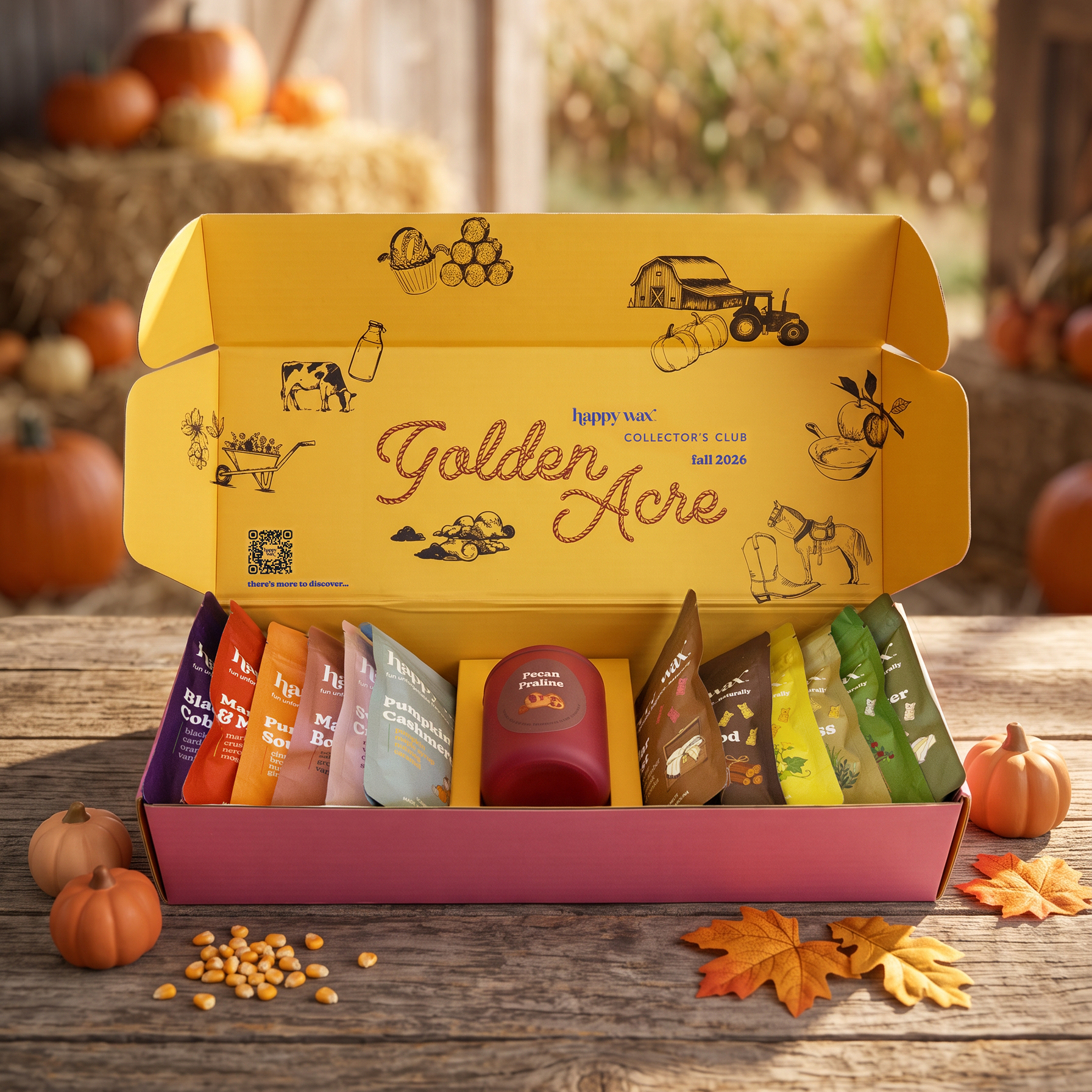 Happy Wax Golden Acre Collector's Club Fall seasonal box open displaying 13 scented wax melts on a wood table in a barn setting with pumpkins and hay.