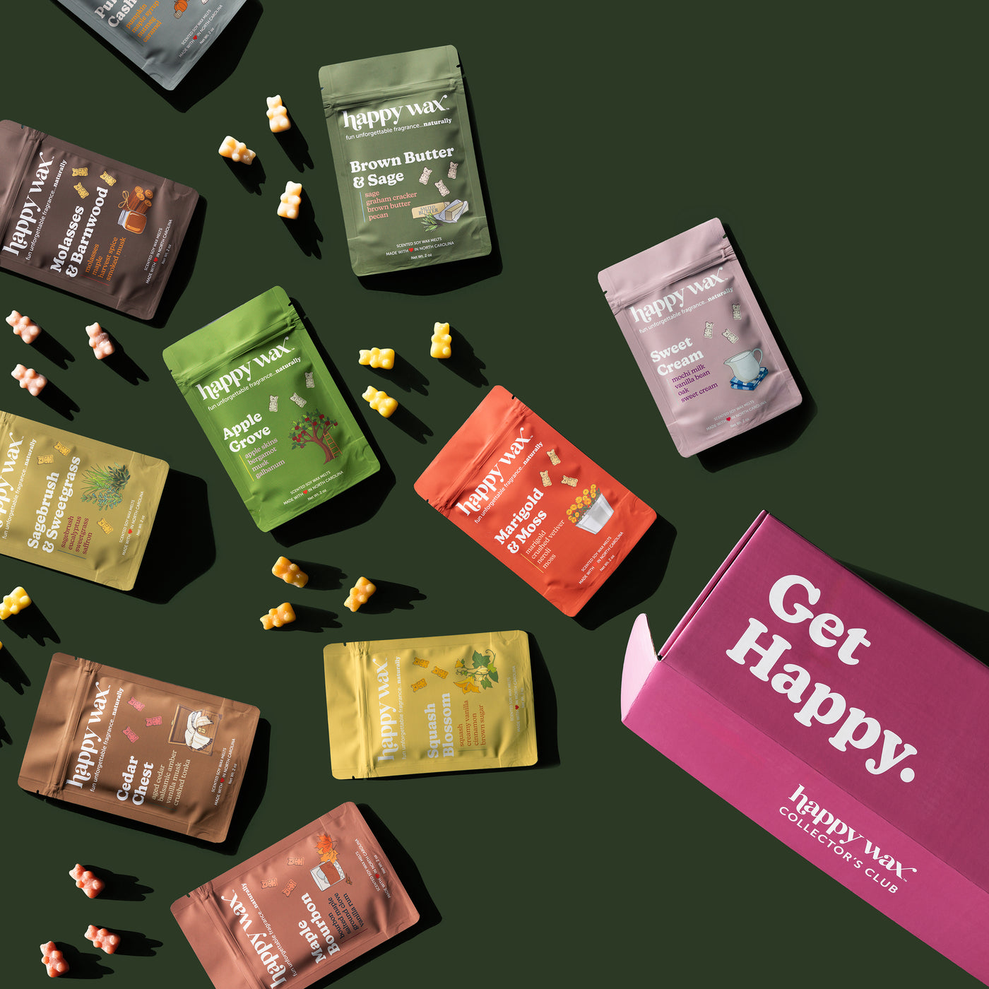 Happy Wax Golden Acre Collector's Club box with various Fall seaonal scent pouches scattered on dark green background