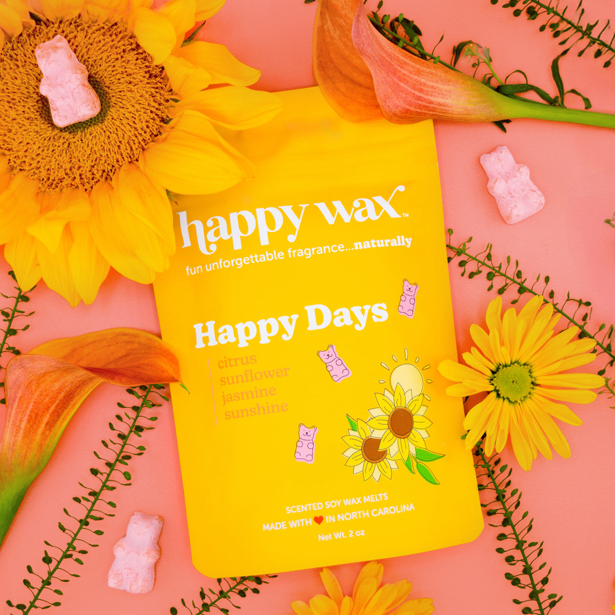 Happy Wax Happy Days package surround by yellow and orange flowers on bright pink background