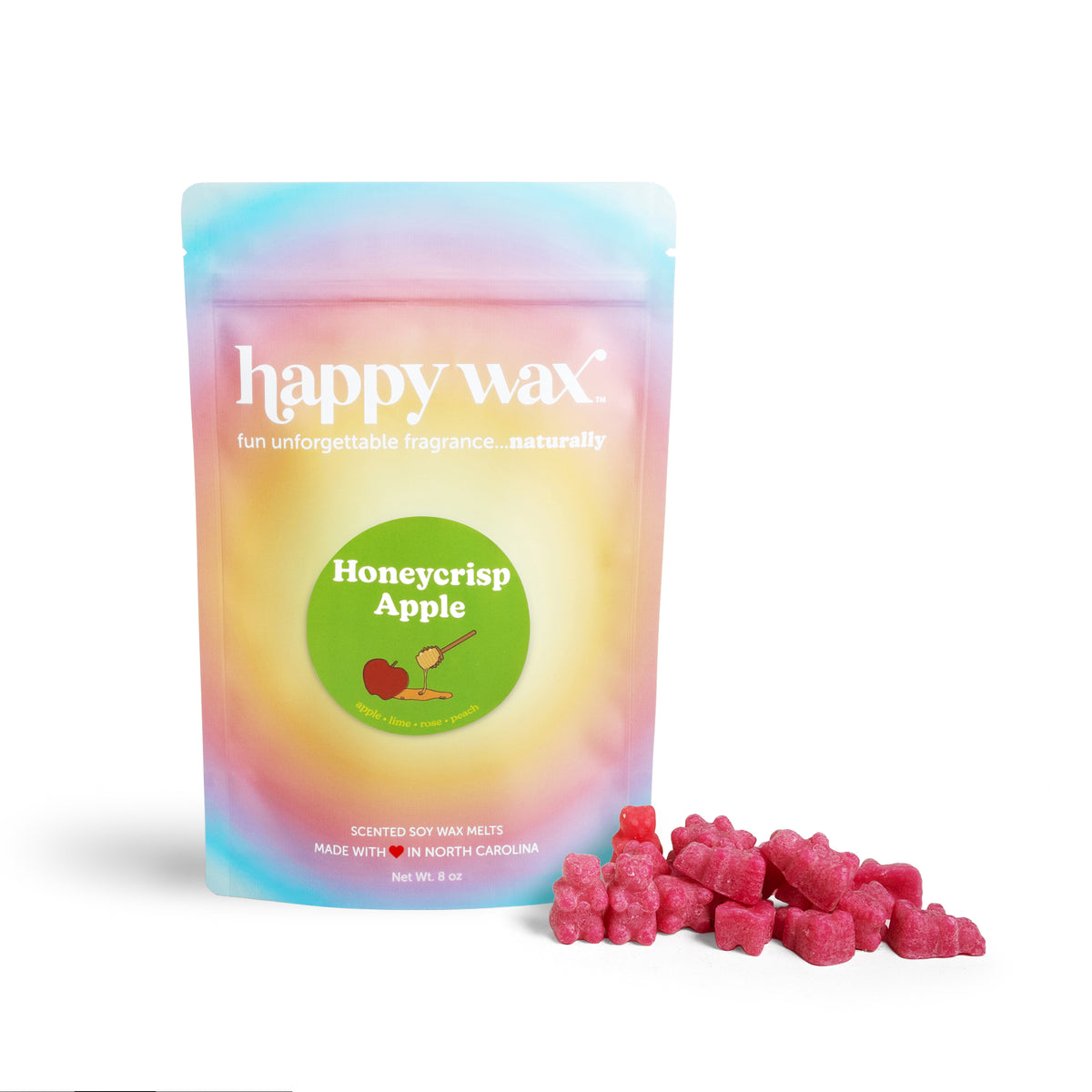 Pastel gradient pouch of happy wax brand soy wax melts with Honeycrisp Apple label, accompanied by pink wax melt bears.