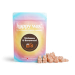 Happy Wax Molasses & Barnwood soy wax melts in peachy-tan pieces next to gradient blue-to-pink pouch packaging.