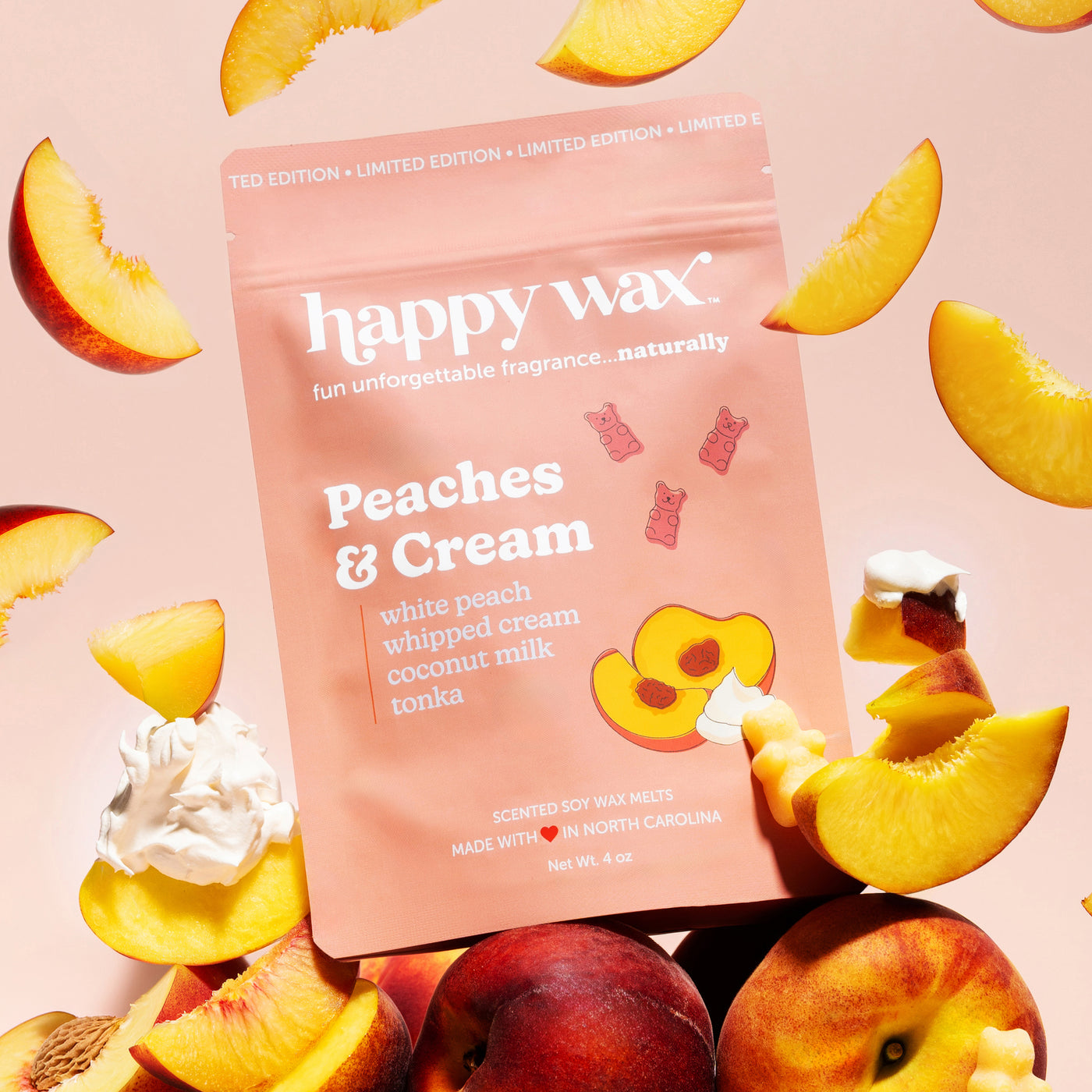 happy wax Peaches & Cream wax melt packaging surrounded by peach slices and cream on a pink background