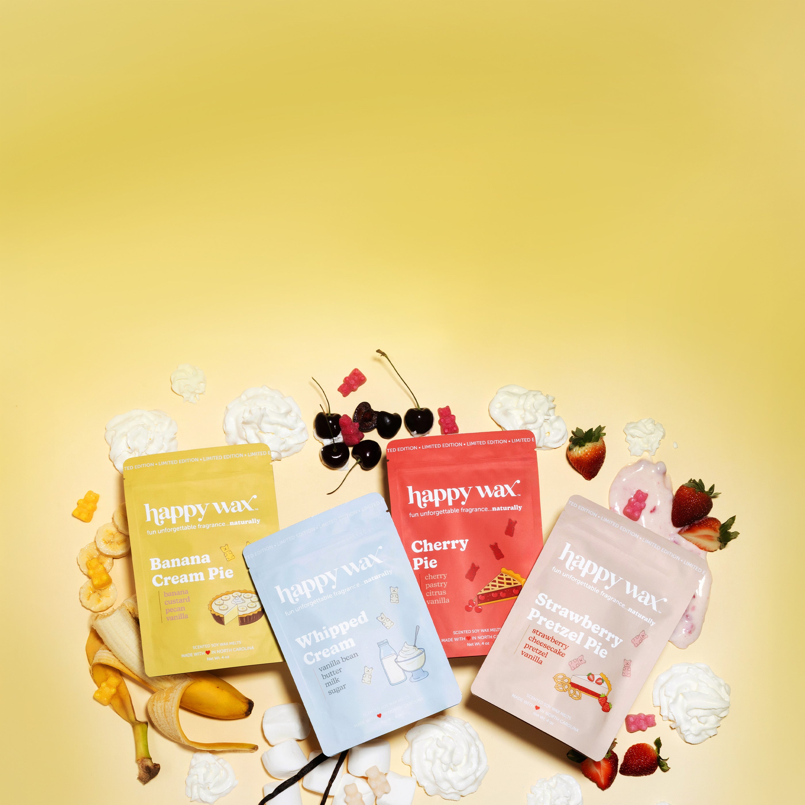 Happy Wax Pie Shop wax melt collection pouches on yellow background with fruit and whipped cream