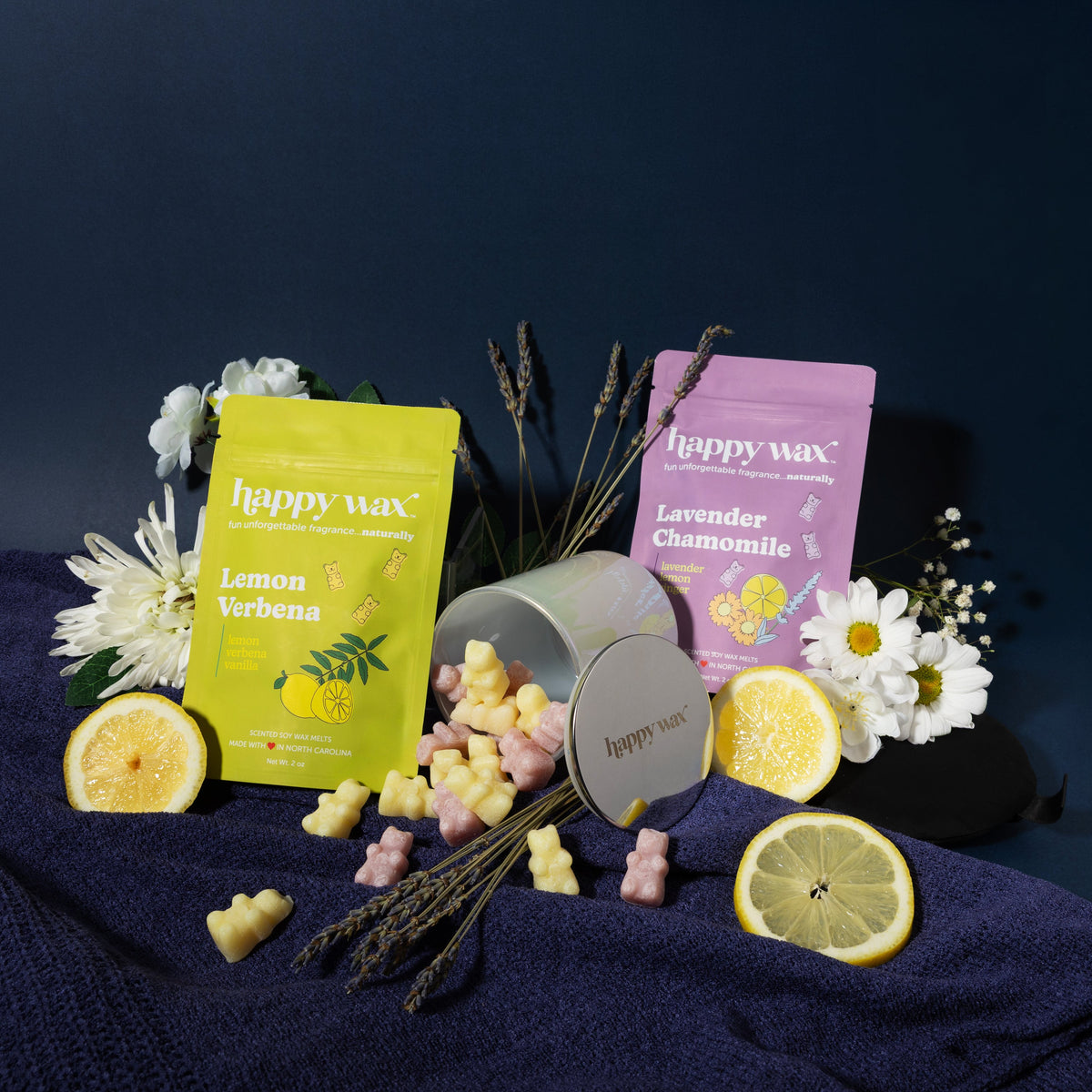 Happy wax melts pouches with iridescent jar on navy background with flowers, lemons, and lavender