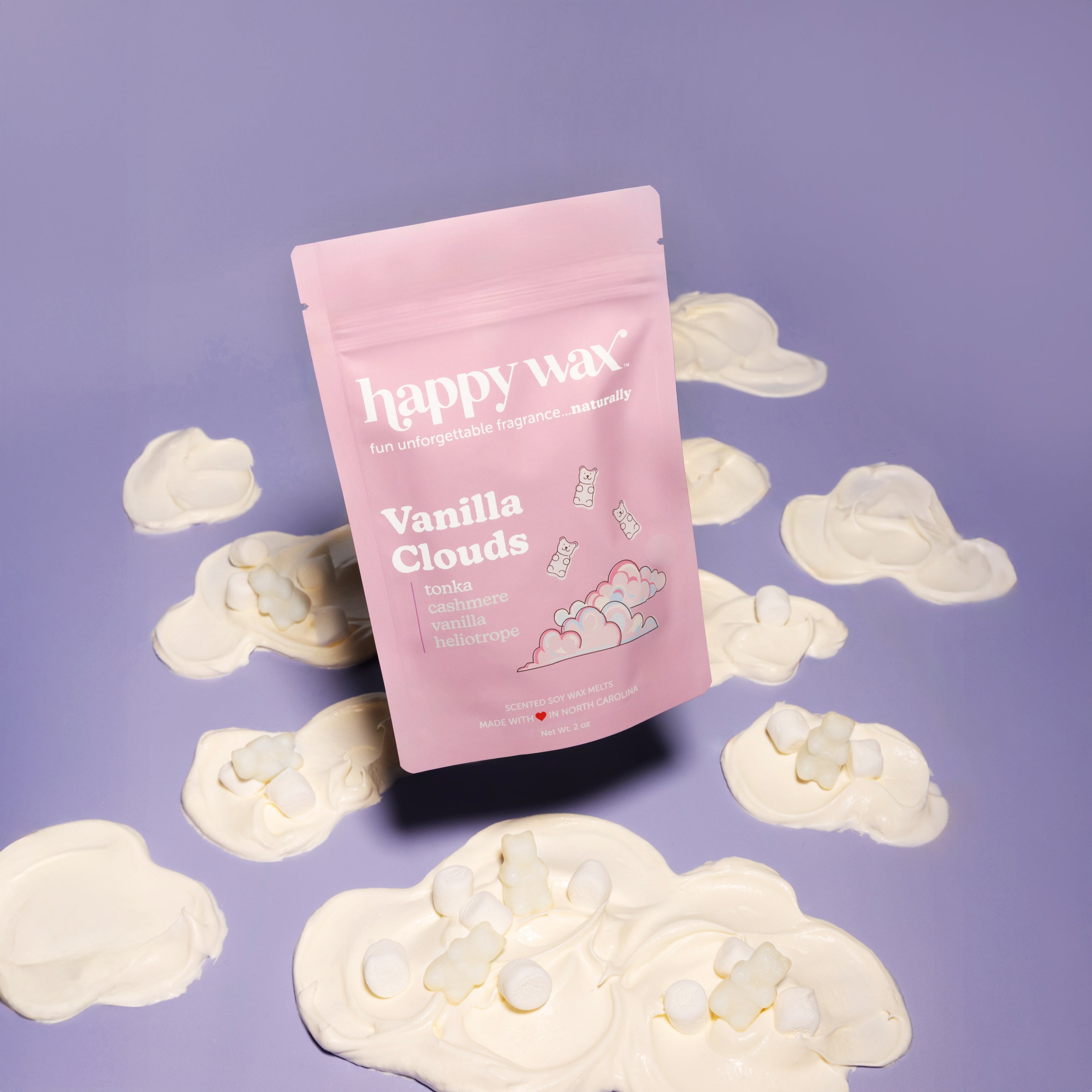 Pink "Vanilla Clouds" wax melt pouch surrounded by cream-colored cloud-shaped wax melts on purple background.